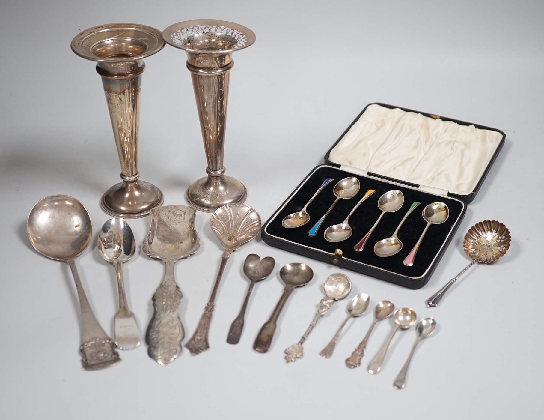 A cased set of six Edwardian silver and enamel teaspoons, William Hair Haseler, Birmingham,1913 and a collection of silver spoons and two silver mounted specimen vases.